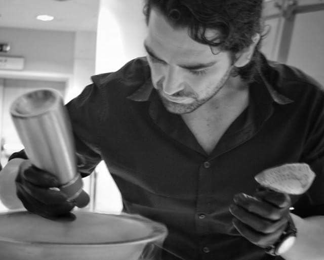 Straining a shaken serve in black gloves behind the event bar