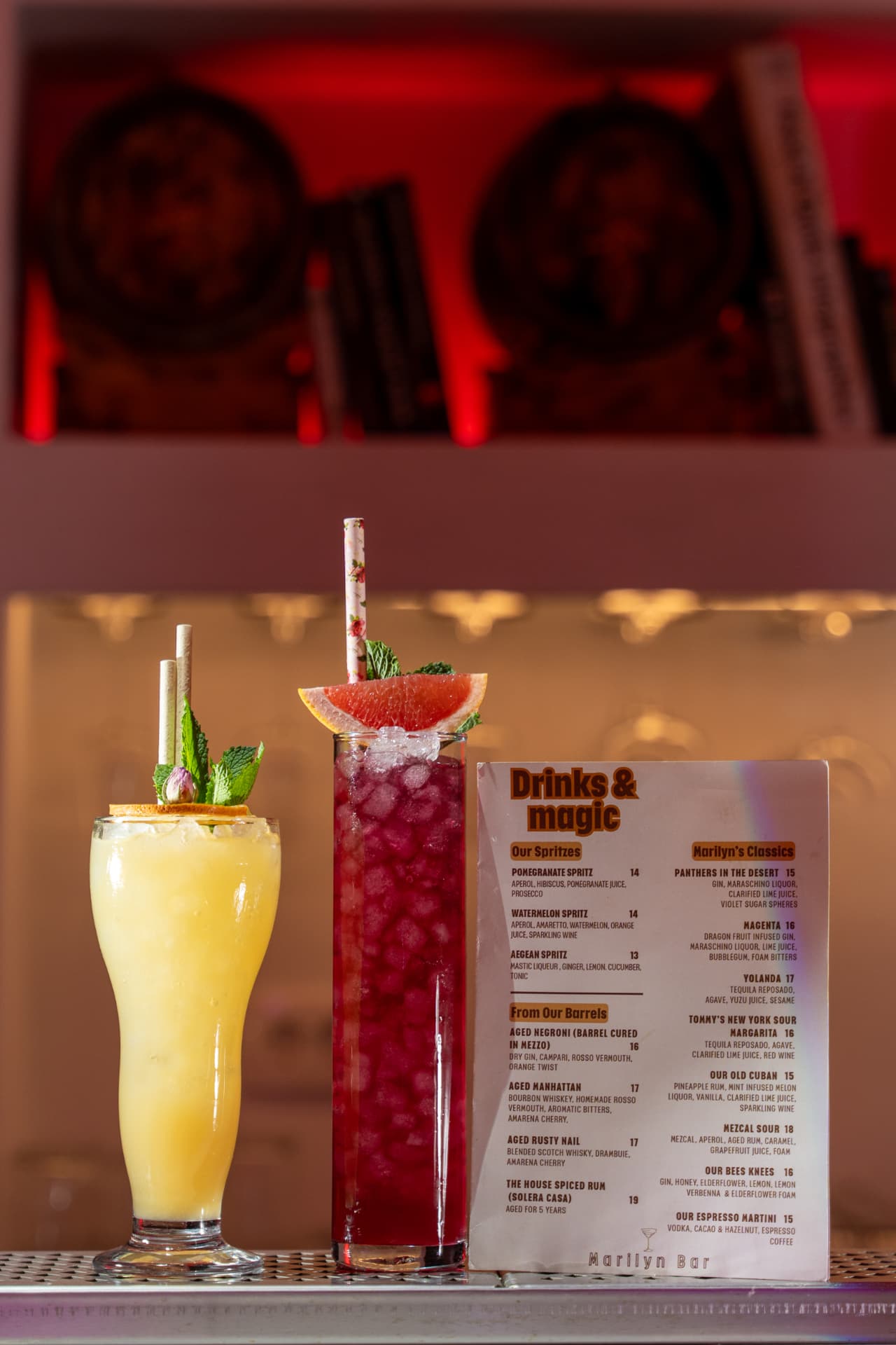 Two long drinks beside the Marilyn Bar 'Drinks & magic' cocktail menu