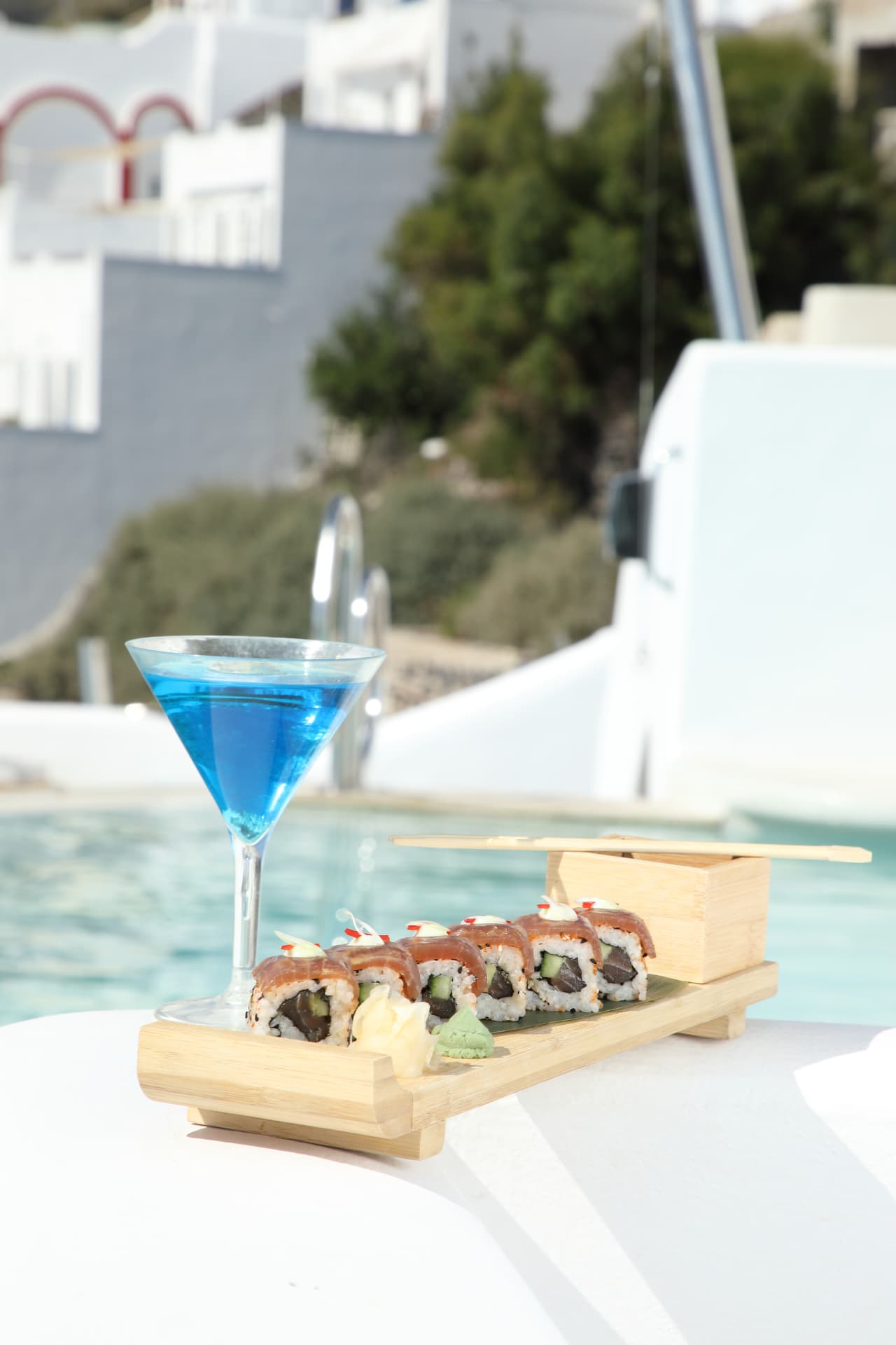 Blue martini beside a sushi board by the pool