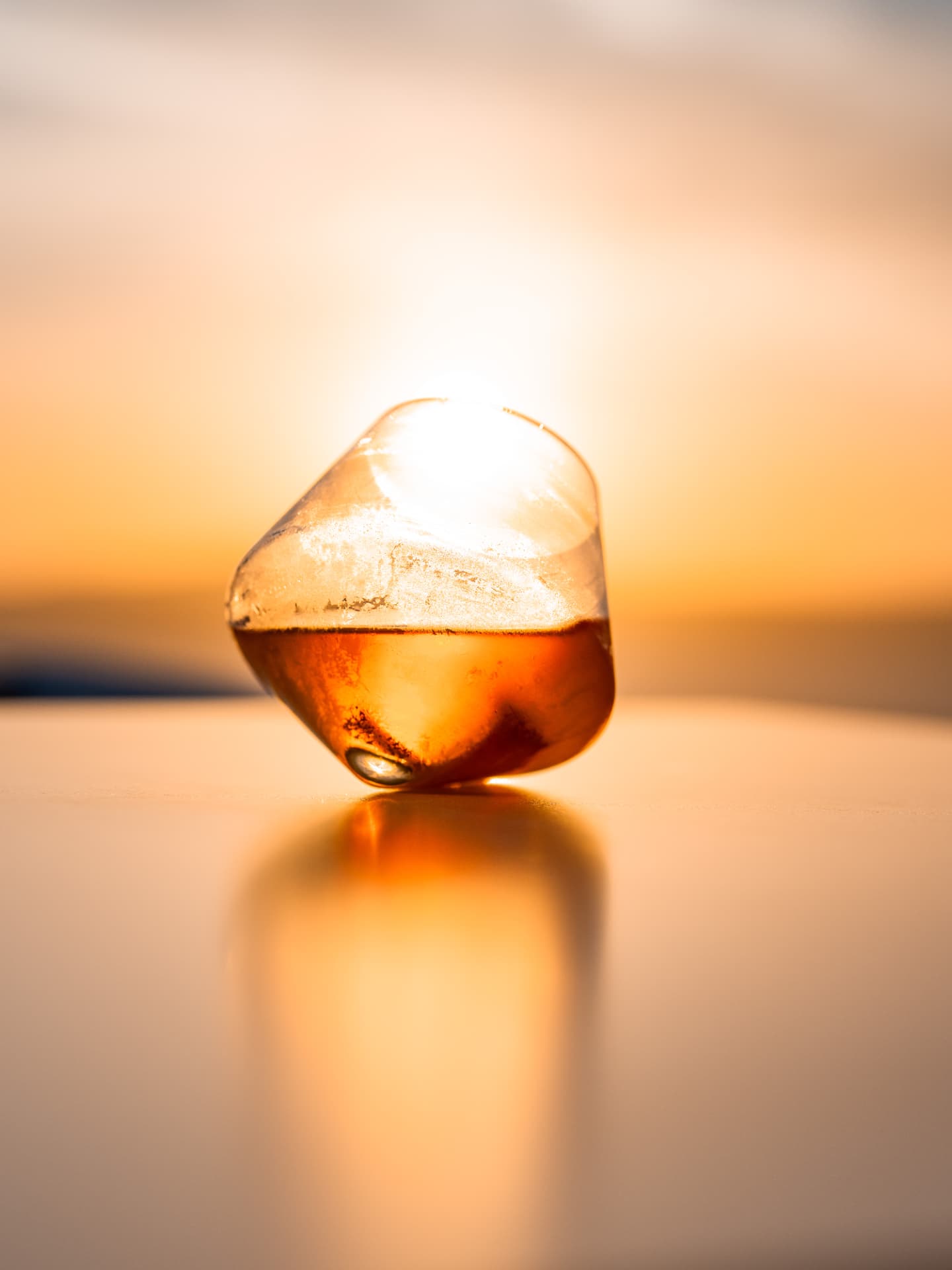 Backlit amber serve glowing against the Aegean sunset