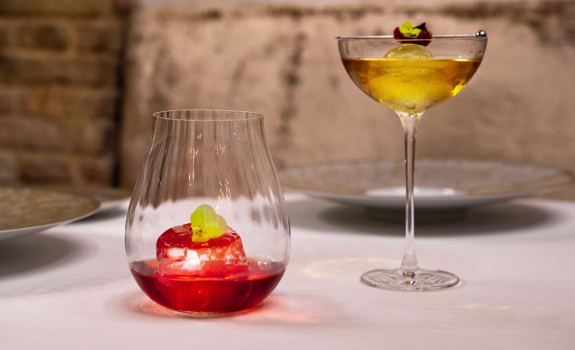 Two signature cocktails on a white linen table at Spondi