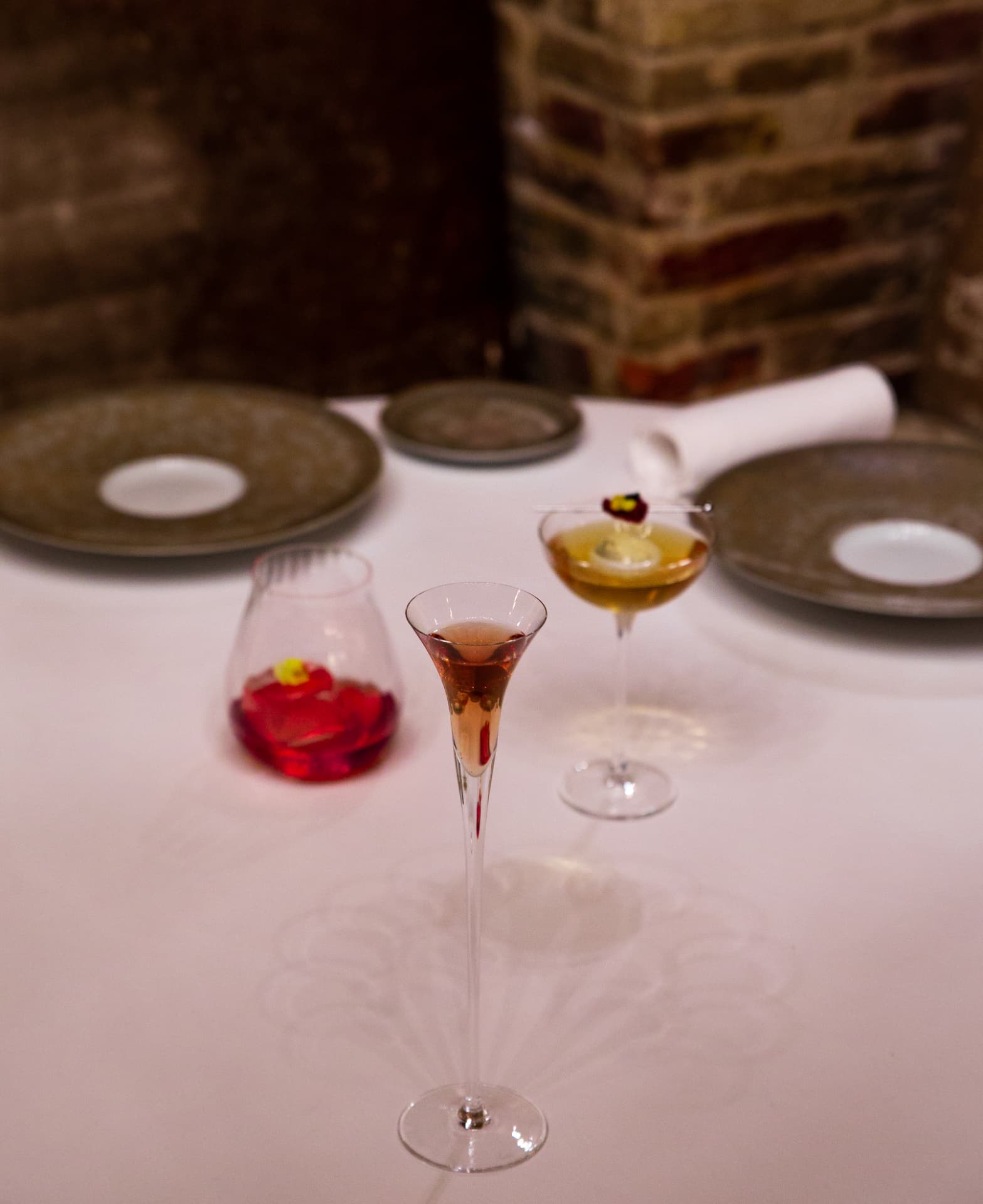 Table setting at Spondi with three cocktails and stone-glazed plates