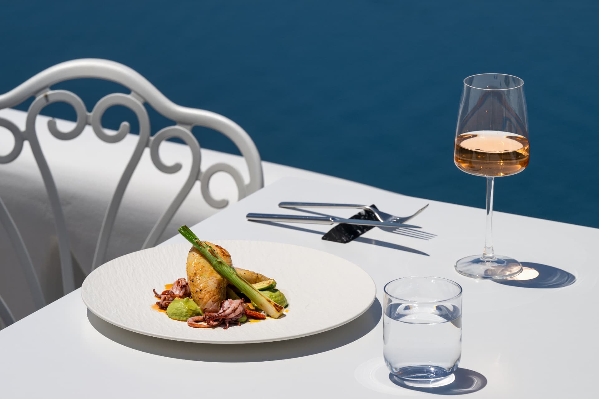 Squid main course paired with a glass of rosé wine by the sea