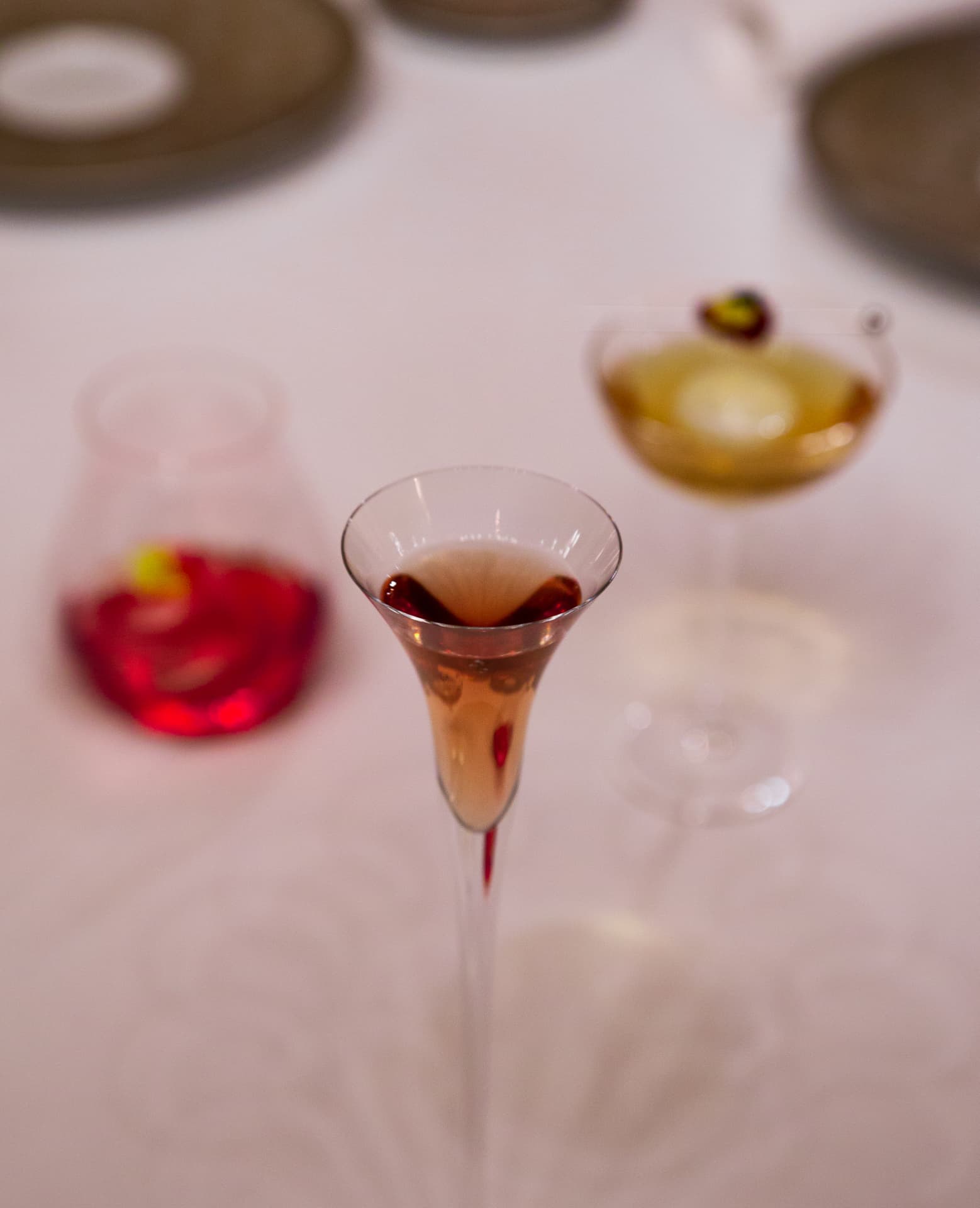 Overhead view of a rosé cocktail with two drinks behind it