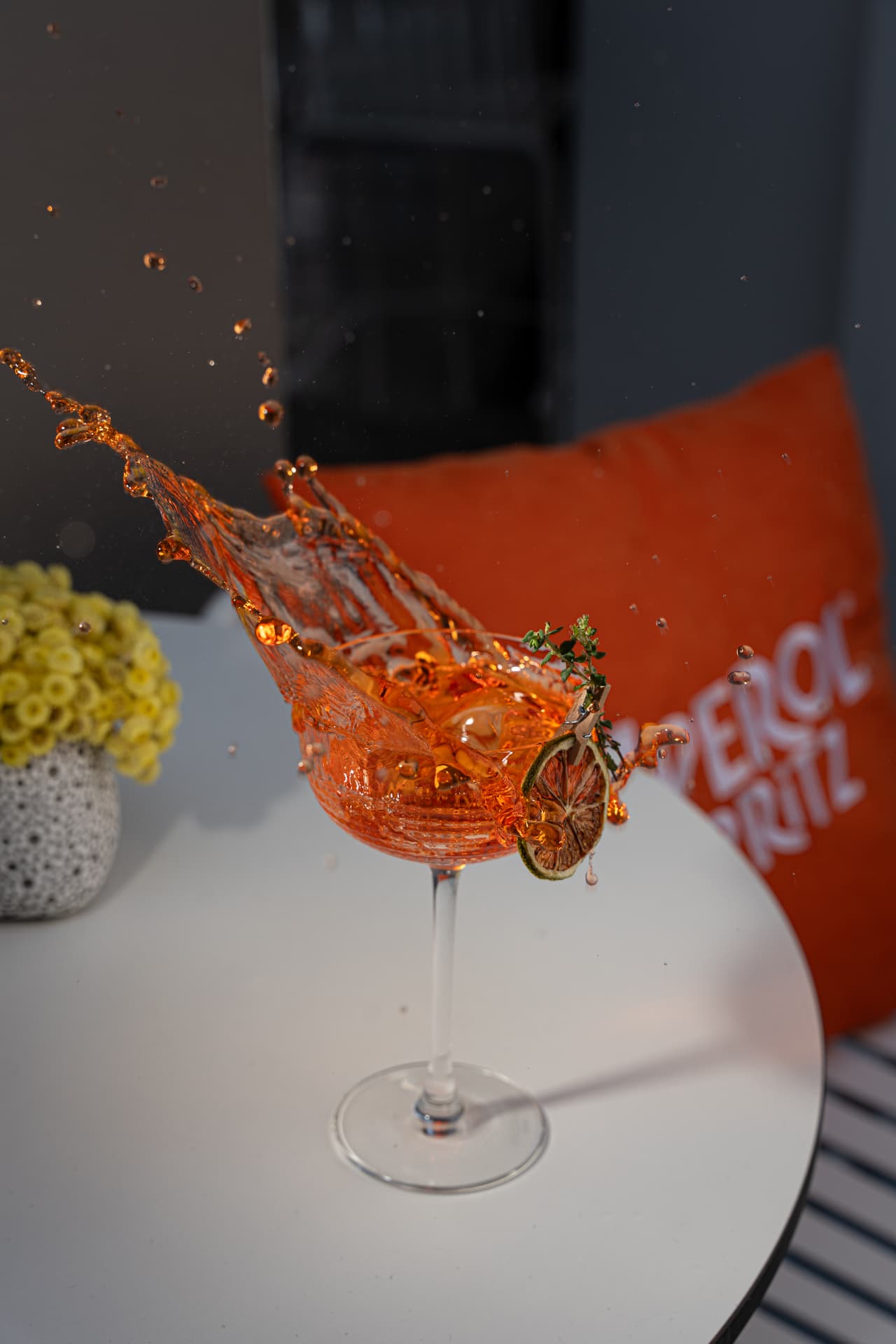 Aperitivo spritz splashing out of the glass on the terrace table