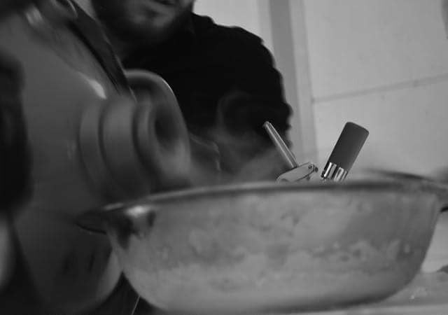 Cream whipper and mixing bowl mid-preparation in black and white