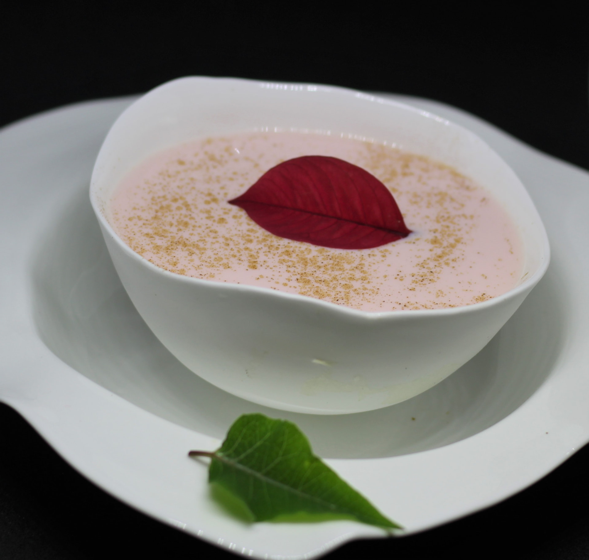 Pale rose serve in a porcelain bowl dusted with spice and finished with a red leaf