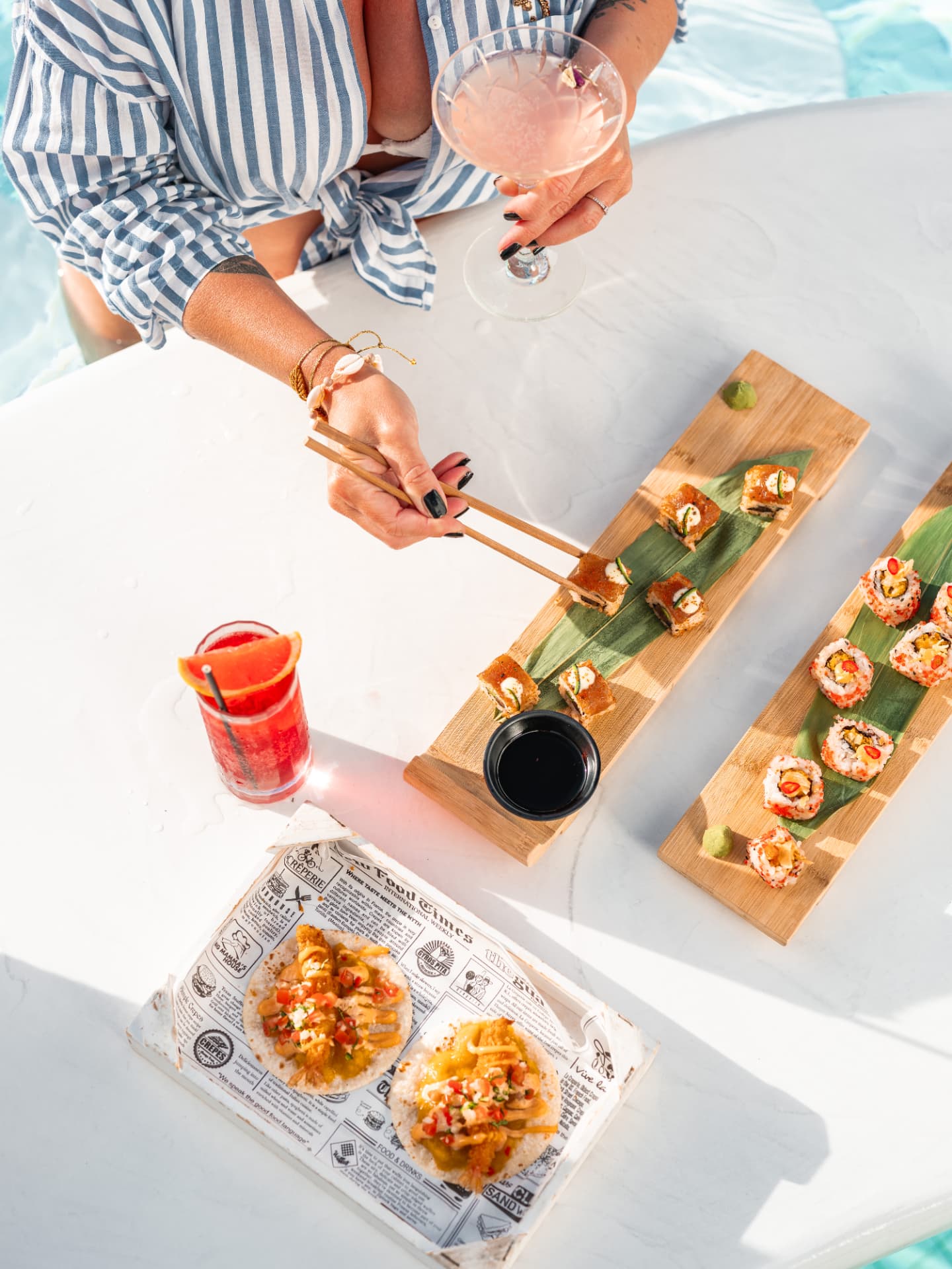 Guest enjoying sushi and cocktails at the pool bar, seen from above