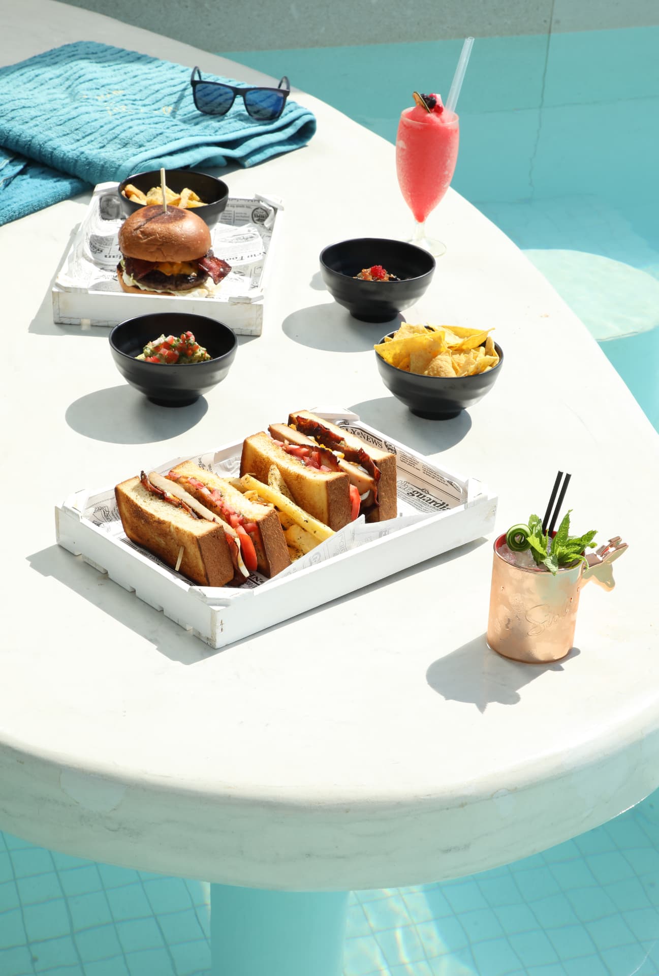 Poolside sharing plates with a frozen daiquiri and copper mule cup