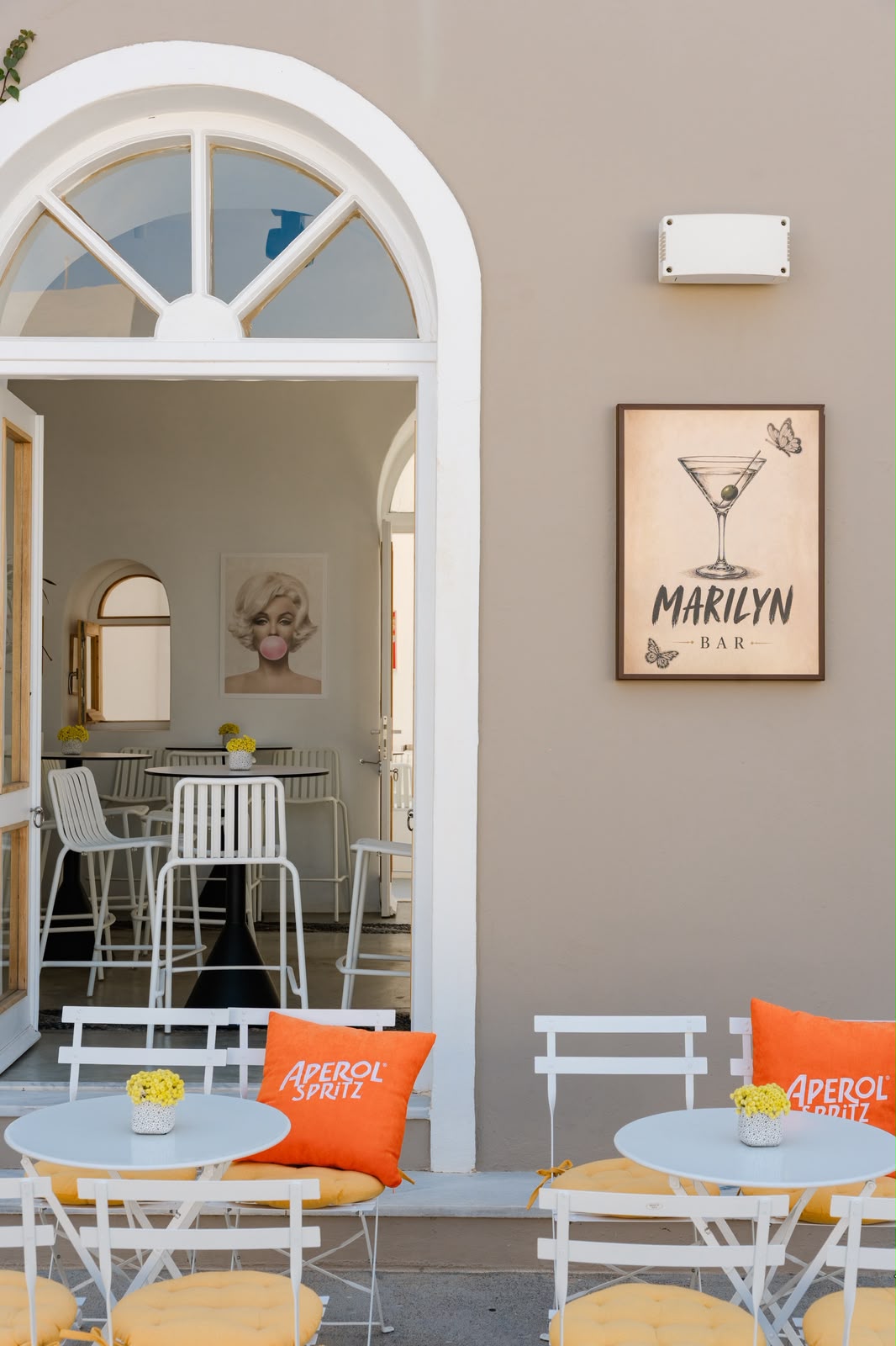 Daytime view of the Marilyn Bar arched entrance with Aperol Spritz seating